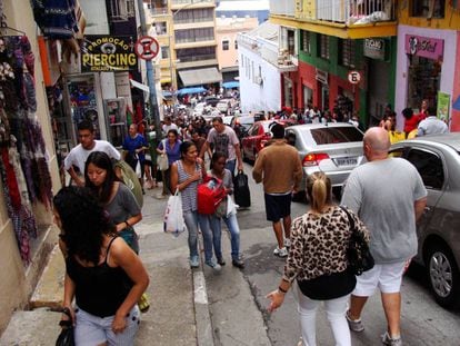 Pedestres e carros em uma rua comercial de S&atilde;o Paulo.    