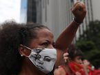 A demonstrator wearing a mask depicting late activist and councilwoman Marielle Franco raises her fist as she takes part in a protest against Brazil's President Jair Bolsonaro and his handling of the coronavirus disease (COVID-19) outbreak, in Sao Paulo, Brazil, January 31, 2021. REUTERS/Amanda Perobelli
