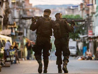 Policiais do BOPE patrulham as ruas das favelas da Maré.