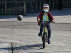 Menino anda de bicicleta com uma máscara em Pequim.