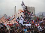 Manifestantes suben al monumento al general Baquedano durante el octavo día de protestas contra el gobierno del presidente Sebastián Piñera el 25 de octubre de 2019 en Santiago, Chile. 