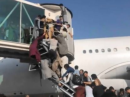 Afganos intentan acceder a un avión en el aeropuerto de Kabul, este lunes.