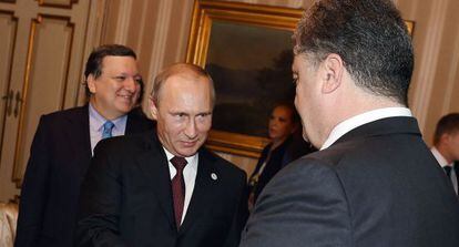 Putin cumprimenta seu homólogo ucraniano, Petro Poroshenko.