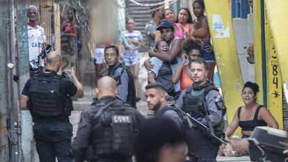 Moradores do Jacarezinho observam agentes da Polícia Civil que participavam da operação que terminou com a morte de 28 pessoas, no dia 6 de maio.