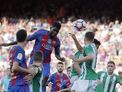 Samuel Umtiti cabeceia a bola no jogo entre Barcelona e Betis. / Manu Fernández (AP)