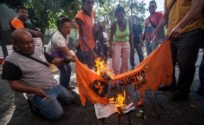 Chavistas queimam bandeira de partido opositor na Venezuela.