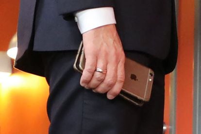 O presidente francês, Emmanuel Macron, com dois de seus telefones durante uma cúpula europeia em novembro 2017.