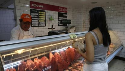 Mulher compra carne no Rio. 