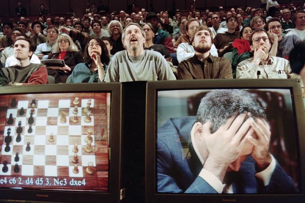 Fãs de xadrez acompanham surpresos o jogo entre a máquina Deep Blue, da IBM, e o campeão do mundo, Gary Kasparov, que aparece desesperado no monitor.