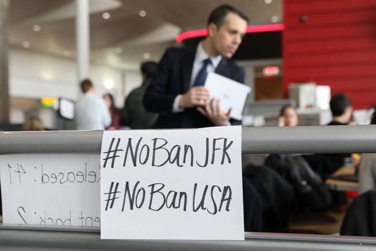 Cartazes contra a ordem de Trump no aeroporto JFK de Nova York.