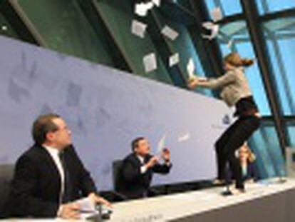 Aos gritos, uma mulher invadiu o recinto, pulou sobre a mesa e atirou papéis em Mario Draghi, que precisou deixar a sala