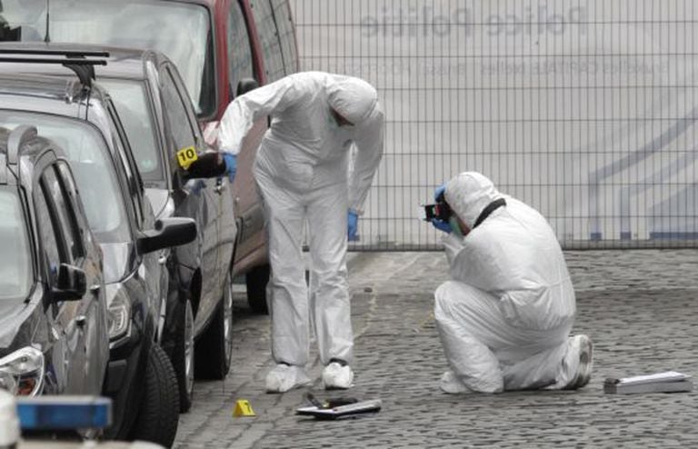 Forenses examinam o lugar do tiroteio de Bruxelas.