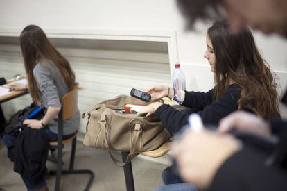Garota francesa consulta seu celular na sala de aula.