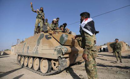 Soldados rebeldes sírios apoiados pela Turquia, num veículo militar na aldeia de Yabisa, perto da fronteira entre os dois países.