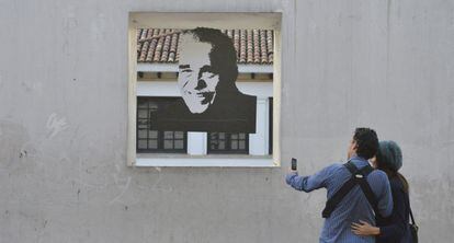 Um casal tira uma foto de um retrato de García Márquez em frente à Casa da Moeda, no centro de Bogotá (Colômbia).
