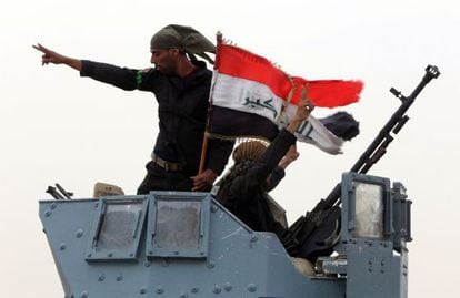 Forças iraquianas celebram a tomada de um posto de controle perto de Mossul.