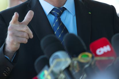Detalhe da gravata do presidente Jair Bolsonaro estampada com desenhos de rifles.