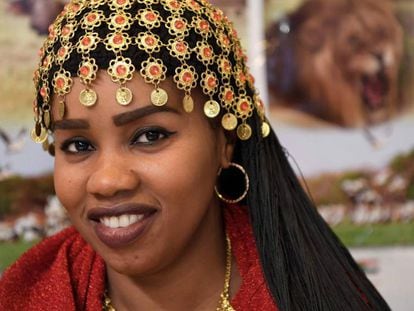 Mulher com penteado tradicional do Sudão posa no estande promocional de seu país na Feira Internacional de Turismo de Madri (Fitur).