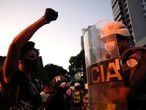 A protester raises a fist in front of a police officer during a demonstration against Brazilian President Jair Bolsonaro and in support of democracy in Sao Paulo, Brazil June 7, 2020. REUTERS/Amanda Perobelli
