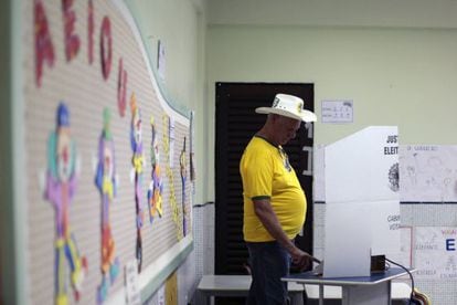 Um homem com camiseta amarela vota em uma escola em Bras&iacute;lia.