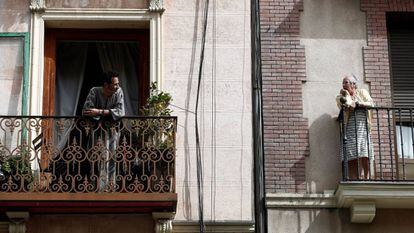Vizinhos conversam pela sacada em um prédio em Madri.