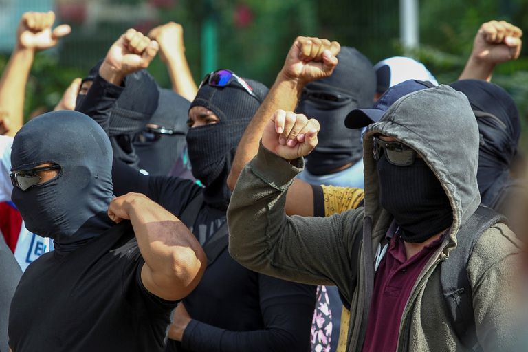 AME4923. FORTALEZA (BRASIL), 20/02/2020.- Personas encapuchadas y enmascaradas -supuestamente agentes de la policía- se concentran en el 18 Batallón de la Policía Militar durante el segundo día de huelga policial este jueves a la ciudad de Fortaleza, en el estado Ceará (Brasil). El presidente de Brasil, Jair Bolsonaro, autorizó este jueves el uso de las Fuerzas Armadas para garantizar la seguridad en el estado de Ceará (noreste), escenario de motines por parte de policías que exigen un aumento de sus salarios. Los militares permanecerán inicialmente desde hoy y hasta el próximo 28 de febrero en diversos puntos de Ceará a ser definidos por el Ministerio de Defensa, según el decreto firmado por Bolsonaro, líder de la extrema derecha brasileña y capitán de la reserva del Ejército. EFE/ Jarbas Oliveira