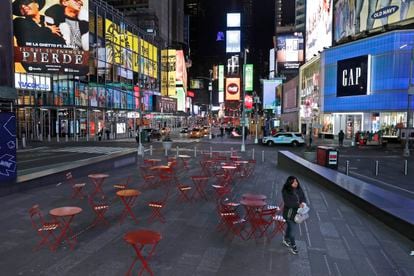 Mulher trafega em uma Times Square quase vazia, em Nova York, na noite de segunda.