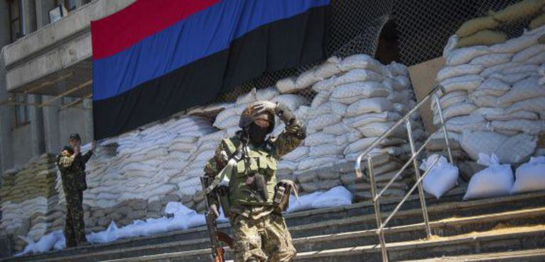 Um miliciano passa pela entrada de uma delegacia ocupada por ativistas pró-Rússia em Slaviansk.