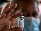 A health worker holds an empty vial of the Cuban vaccine candidate Abdala against COVID-19, during a mass vaccination campaign at the Andres Blanco complex of Fuerte Tiuna in Caracas on June 30, 2021. - The Venezuelan government announced on June 24, 2021 it agreed with Cuba the purchase of 12 million doses of the Abdala vaccine against COVID-19, which according to the laboratory which developed it has an effectiveness of 92% and waits for the approval of the WHO. (Photo by Yuri CORTEZ / AFP)
