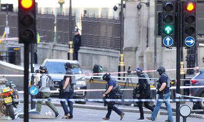 Agentes da policial antiterrorismo atravessam a zona isolada nesta quarta-feira na Ponte de Westminster, em Londres, em proximidade da sede do Parlamento britânico.