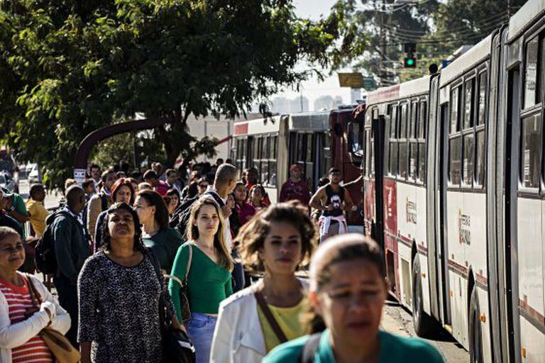 Passageiros em ponto de ônibus em São Paulo.