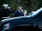 TOPSHOT - US President Donald Trump (C) walks off Marine One while arriving at Walter Reed Medical Center in Bethesda, Maryland on October 2, 2020, after testing positive for covid-19. - President Donald Trump will spend the coming days in a military hospital just outside Washington to undergo treatment for the coronavirus, but will continue to work, the White House said Friday (Photo by Brendan Smialowski / AFP)