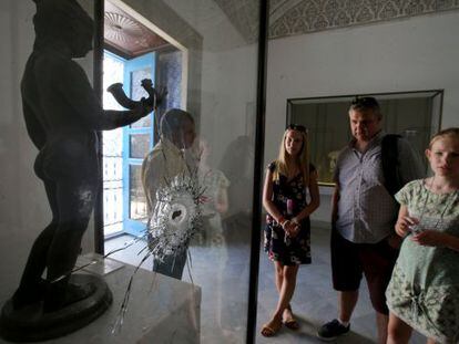 Uma família contempla, na terça-feira no Museu Nacional do Bardo, uma obra baleada durante o atentado islâmico de março passado.