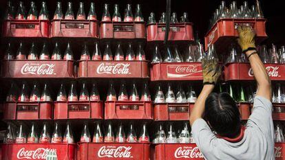 Funcionária empilha caixas de Coca-Cola na Cidade do México, em 2013