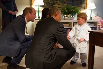 O duque de Cambridge e o presidente dos Estados Unidos, Barack Obama, agachados para falar com o príncipe George.
