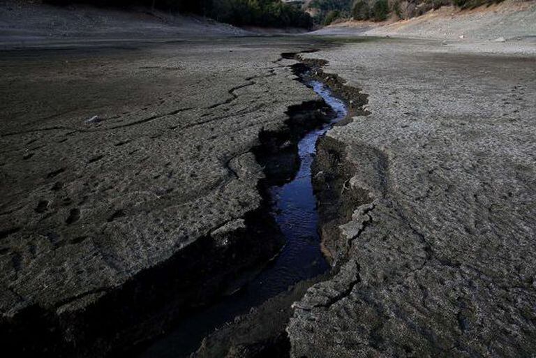 Um fluxo de água atravessa o fundo seco de um reservatório em San Jose, na Califórnia.