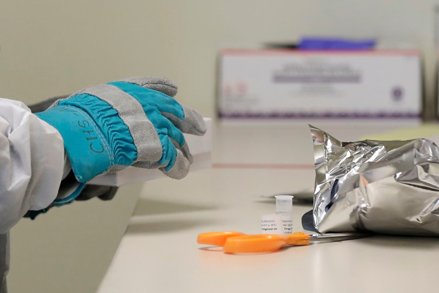 Pesquisador manipula a vacina desenvolvida pelos EUA no primeiro dia do teste clínico, em Seattle.