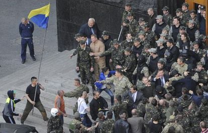 Ativistas entram em confronto com policiais na porta do Parlamento em Kiev.