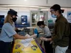 Greek Police wearing face masks to prevent the spread of the new coronavirus, check the documents of the passengers who arrived from Doha, Qatar to the Eleftherios Venizelos International Airport in Athens, Monday, June 15, 2020. Greece is officially open to tourists as of Monday, with the first international flights expected into Athens and the northern city of Thessaloniki where passengers will not face compulsory COVID-19 tests. (AP Photo/Thanassis Stavrakis)