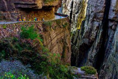 Turistas caminhando pela estrada do túnel de Guoliang, feita na montanha de Wanxian, na província chinesa de Henan.