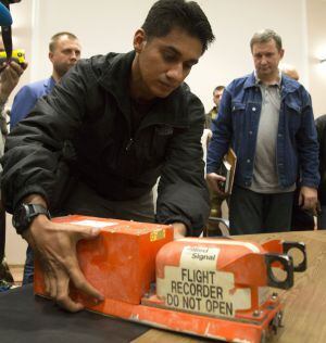 Um pesquisador malásio recolhe as caixas-pretas do MH-017 derrubado na quinta-feira em território ucraniano. / Dmitry Lovetsky (AP)