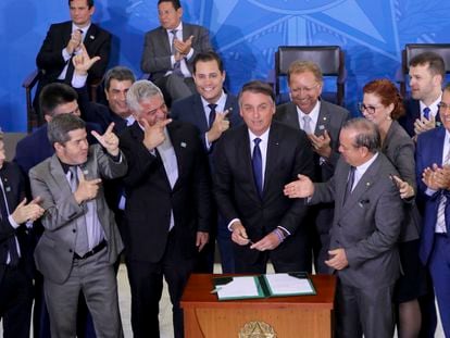 O presidente da República, Jair Bolsonaro, assina o decreto que afrouxa controle de armas, em 2019.