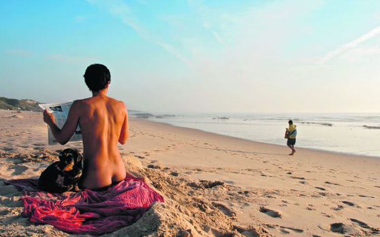 Uma jovem com seu cão na praia portuguesa do Malhão.