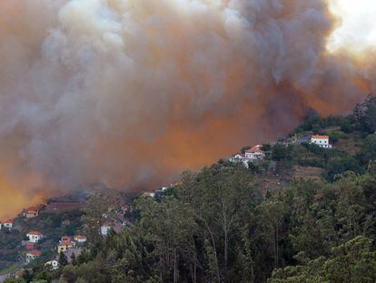 Um incêndio florestal se aproxima das casas de Curral dos Romeiros, nas proximidades de Funchal, na ilha da Madeira (Portugal).