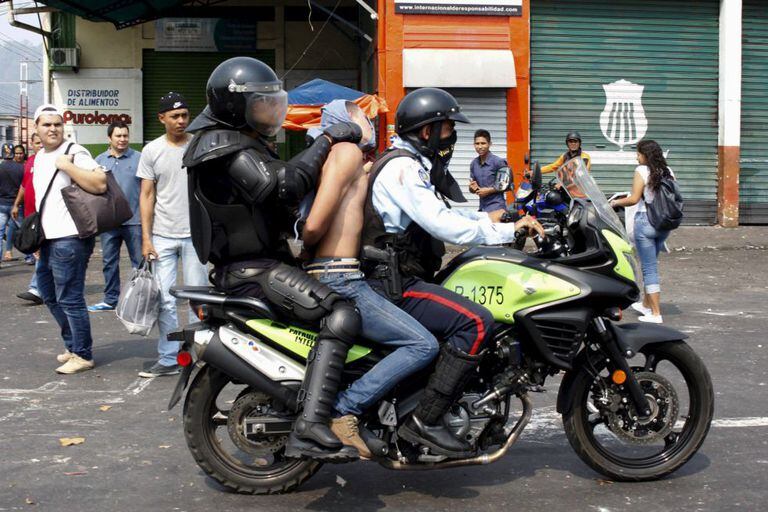 Policiais prendem um manifestante em San Cristóbal em março.