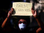 A demonstrator holds a sign reading "Stop killing us, black lives matter", as he takes part in a protest against police violence during operations in slums against drug gangs and racism in Brazil, in front of the Guanabara Palace in Rio de Janeiro, Brazil, May 31, 2020. REUTERS/Pilar Olivares