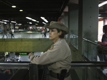 Carolina González, cabo da milícia, observa aos usuários do metro na estação Altamira, em Caracas.