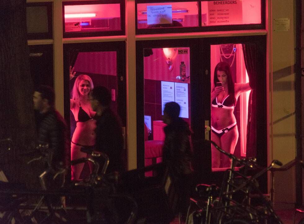 Duas mulheres em uma vitrine no bairro da luz vermelha de Amsterdã em 2015.