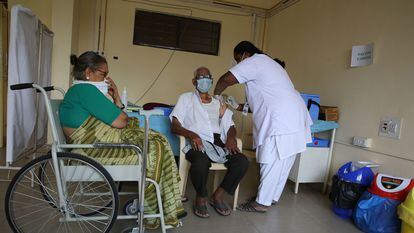 Uma enfermeira injeta uma vacina contra a covid em um idoso no Raman Hospital de Bangalore (Índia).