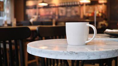 Una taza de café en la mesa de una cafetería.